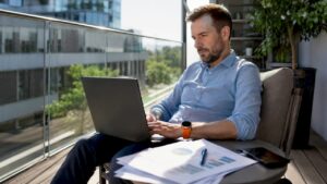 Ein Unternehmer kalkuliert am Laptop sein Werbebudget.